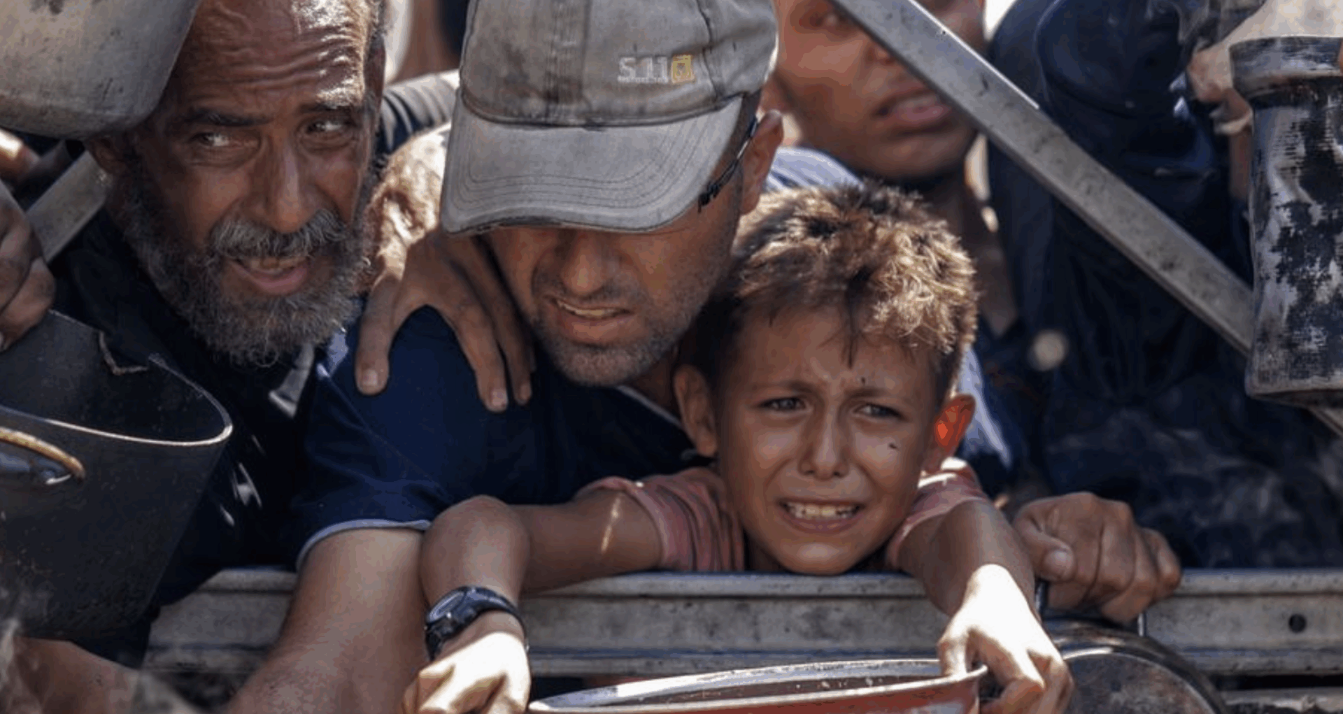 Civiles palestinos, incluido un niño, buscan ayuda humanitaria en Gaza durante la crisis.